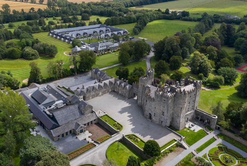 12th-century castle estate with a large courtyard, surrounded by lush Irish greenery