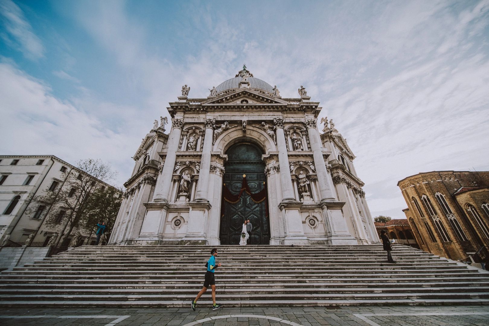 A couple standing in front of an ancient church in Milan during their elopement in Italy