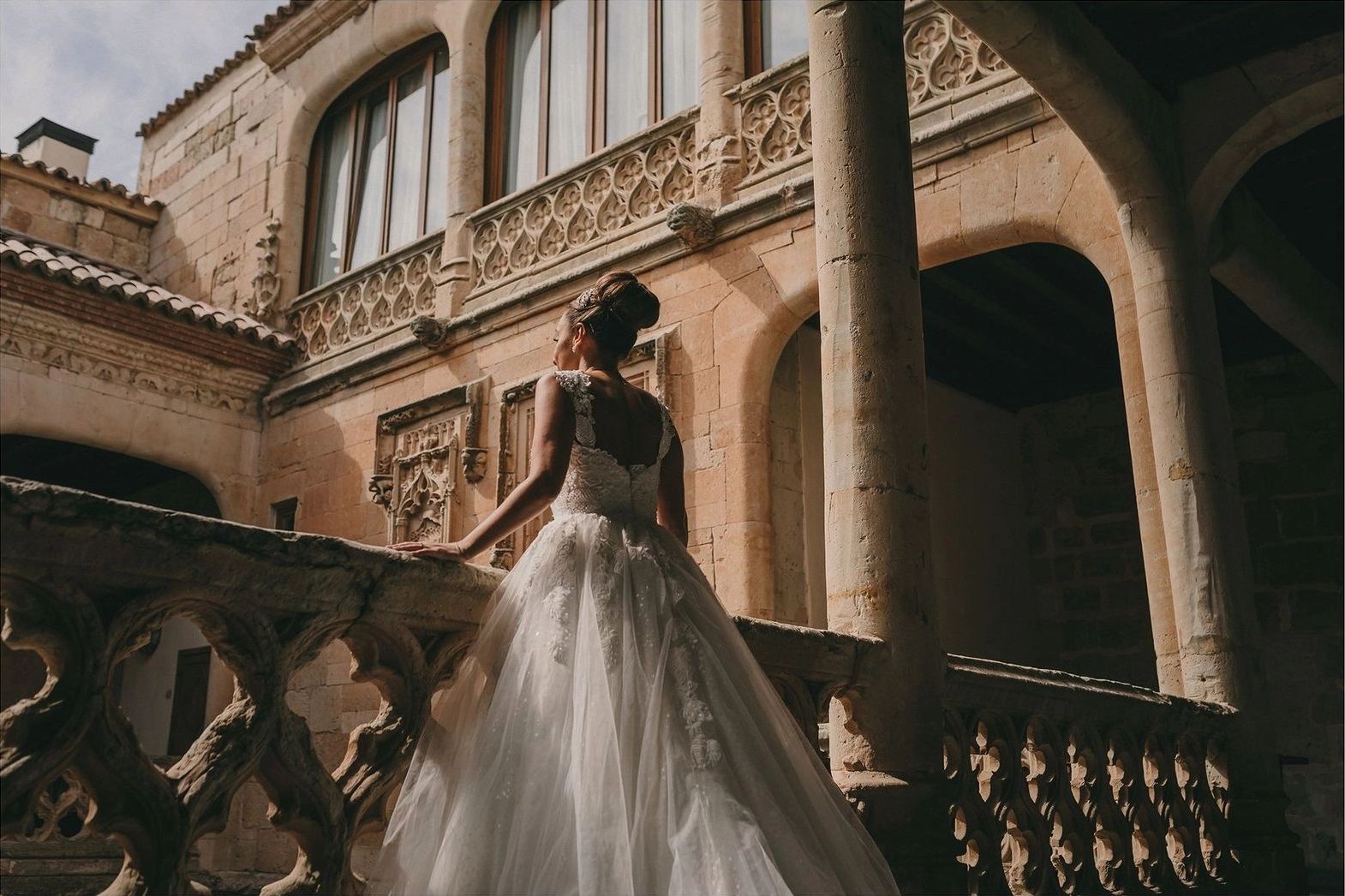 Bride in a balcony of a historic castle in Spain during her destination wedding