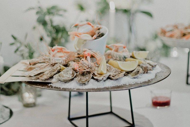 A white plate of seafood with lemon slices