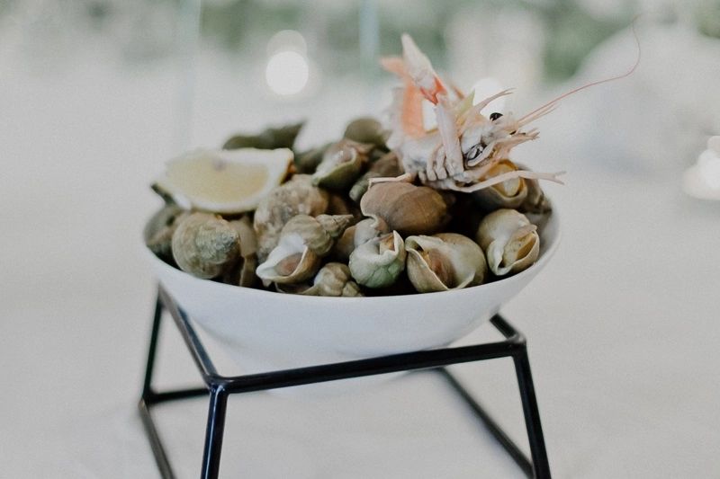 A white bowl with clam shells served on the table