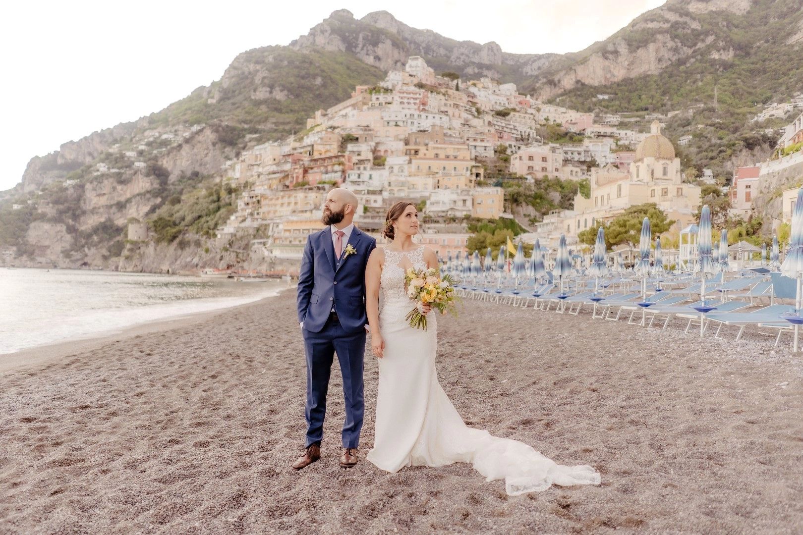 Bride and groom posing on the beach in Positano for their elopement in Italy