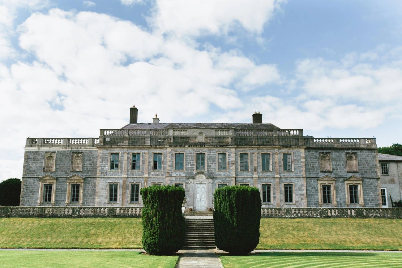 A medieval mansion with a brick-covered facade under a bright sky in Ireland