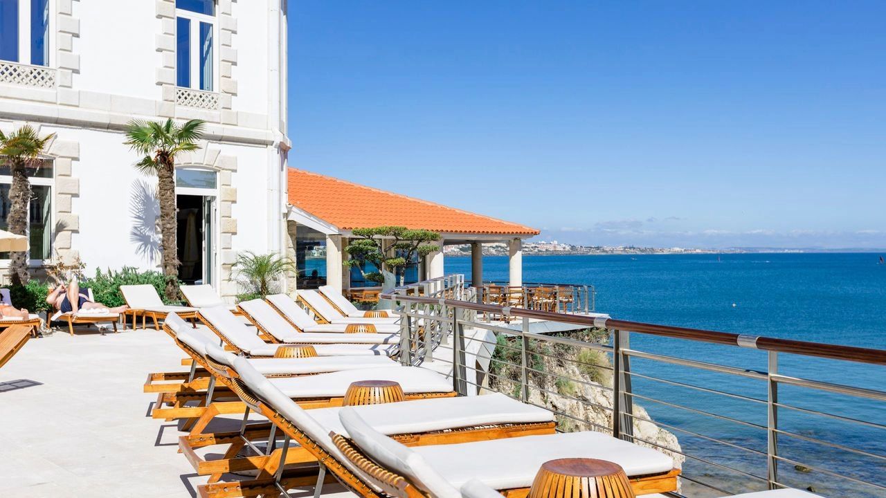 A terrace of a beachside hotel in Cascais overlooking the pristine blue waters of the ocean