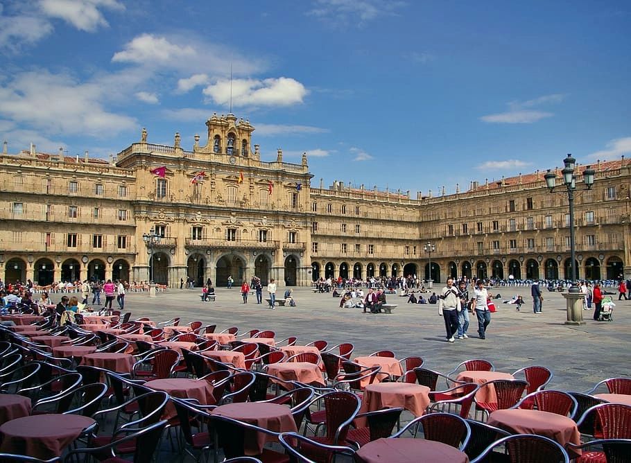 A beautiful baroque square in Salamanca, Spain, called Plaza Mayor with many people walking and visiting