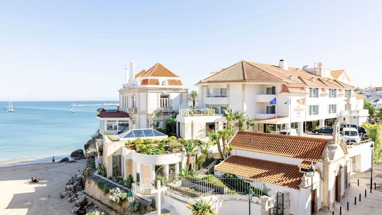 A luxury beachside castle hotel with the sandy shore and the ocean on the edge