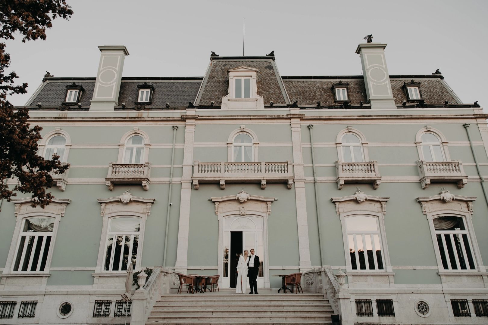 Newlyweds in front of a blue royal palace having a photoshoot after their destination elopement in Portugal