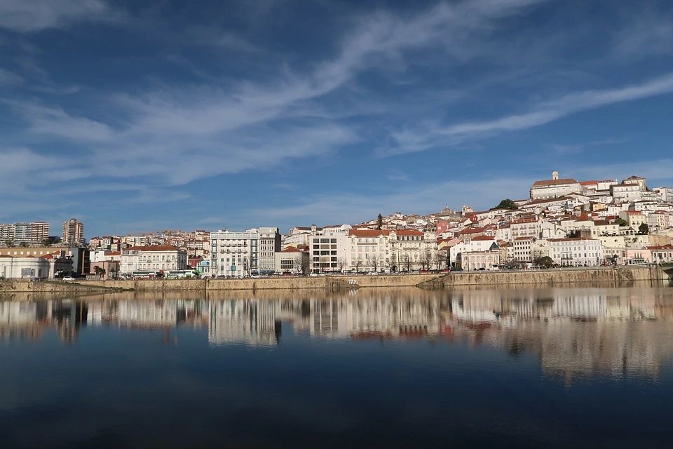 The riverfront city of Coumbra with its tall buildings and orange roofs that look similar to each other
