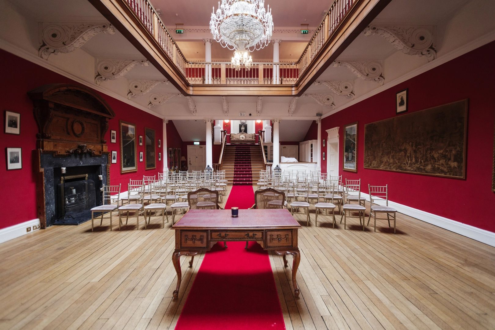 A red ebent room inside a luxury palace hotel in Ireland with chairs arranged for a wedding ceremony