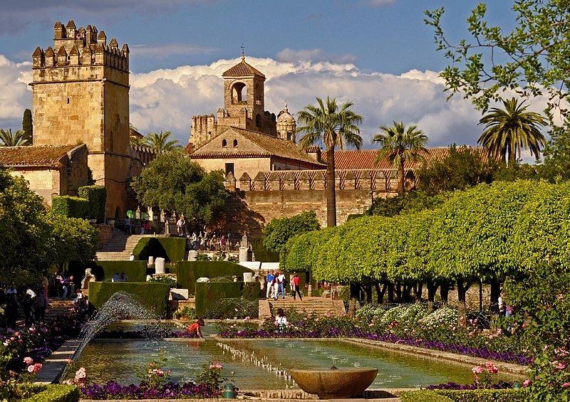 A huge historic mosque in Cordoba, Spain surrounded by trees and greenery
