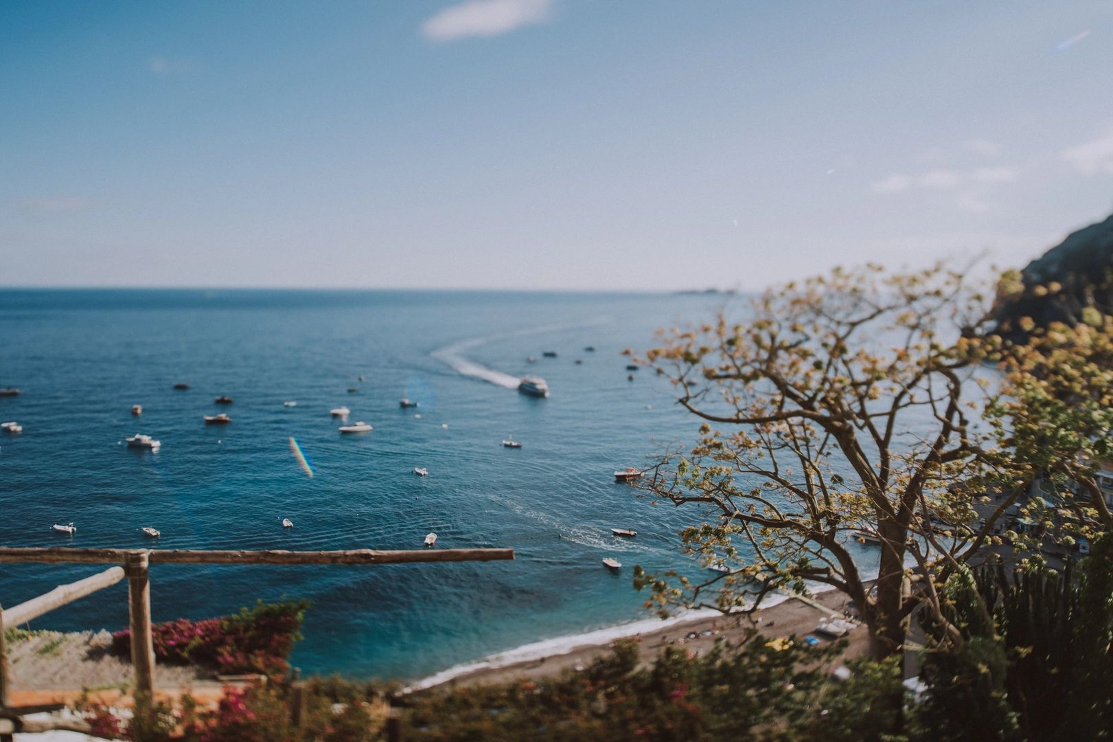 Sardinia’s coast overlooking the sea with boats sailing above it