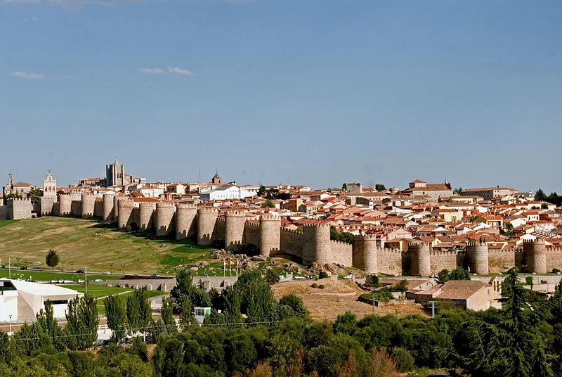 A hilly city in Spain called Ávila with medieval fortresses, houses, and buildings