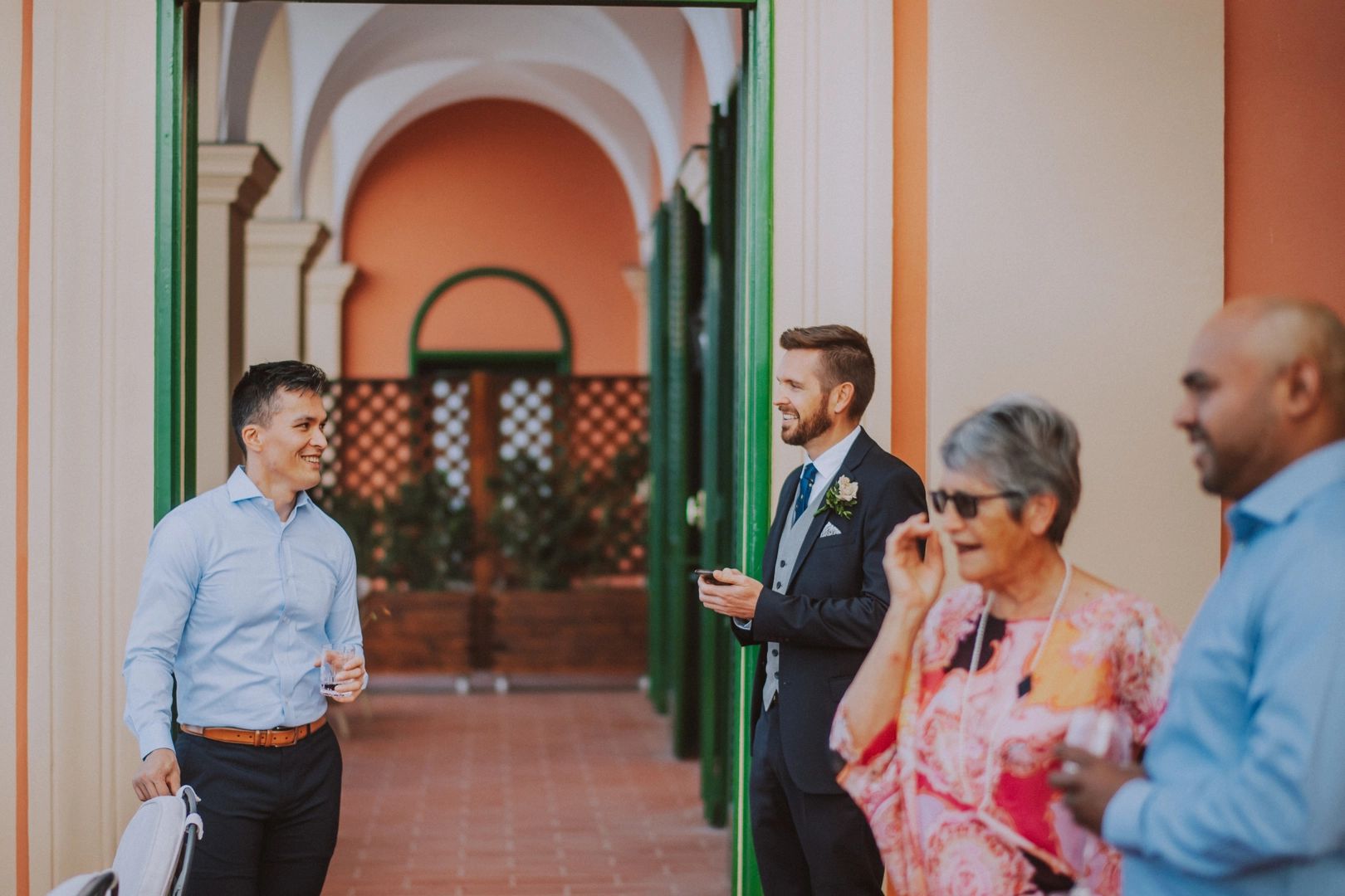 A groom talking to a guy outside the door, with two other people
