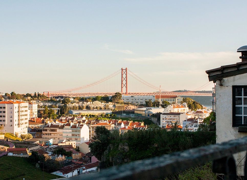 Lisbon’s city center showing its modern and old buildings, the suspension bridge called Ponte 25 de Abril, and Tagus River