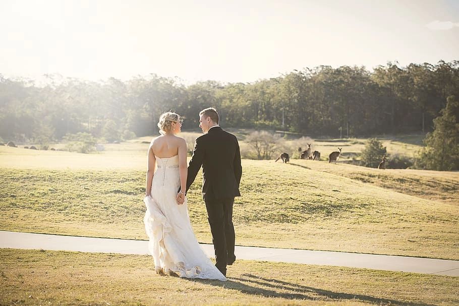 Couple walking along a wide golf course while holding each others’ hands in Portugal