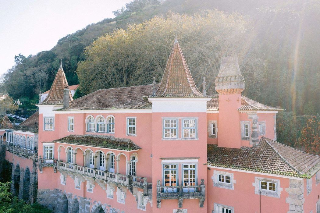 A picturesque medieval palace painted in pink with pointed roofs in Portugal