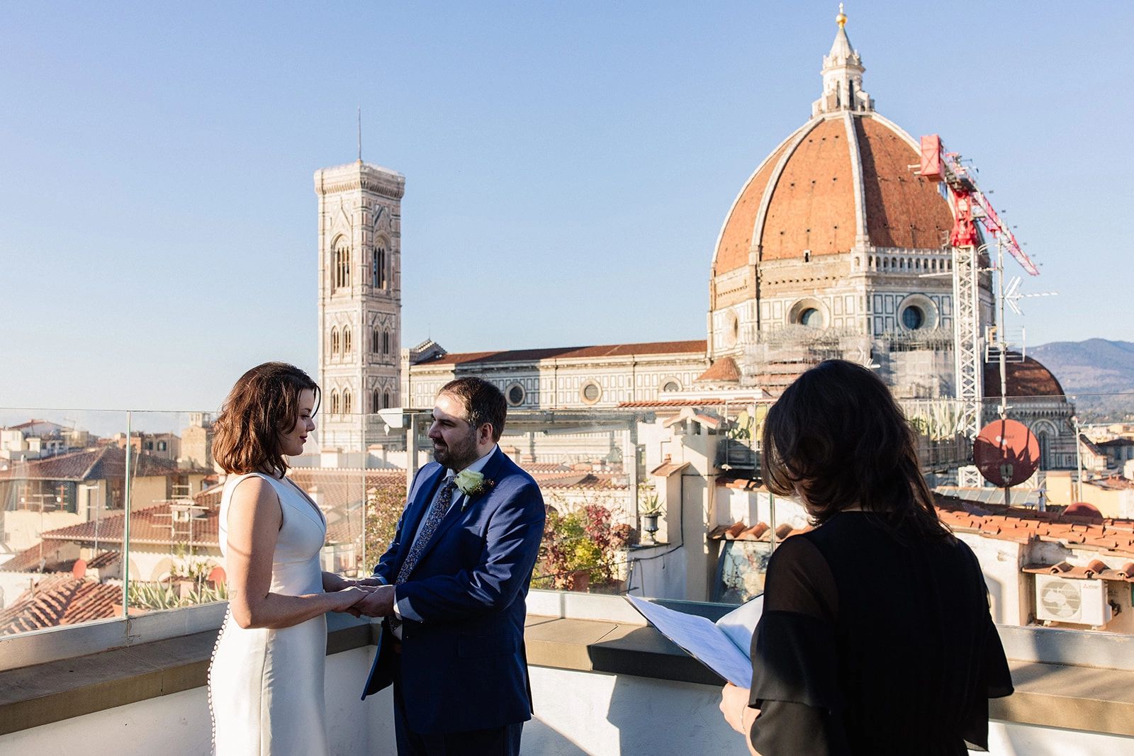 Bride and groom having an outdoor ceremony atop a terrace in Florence, with the famous cathedral in the background