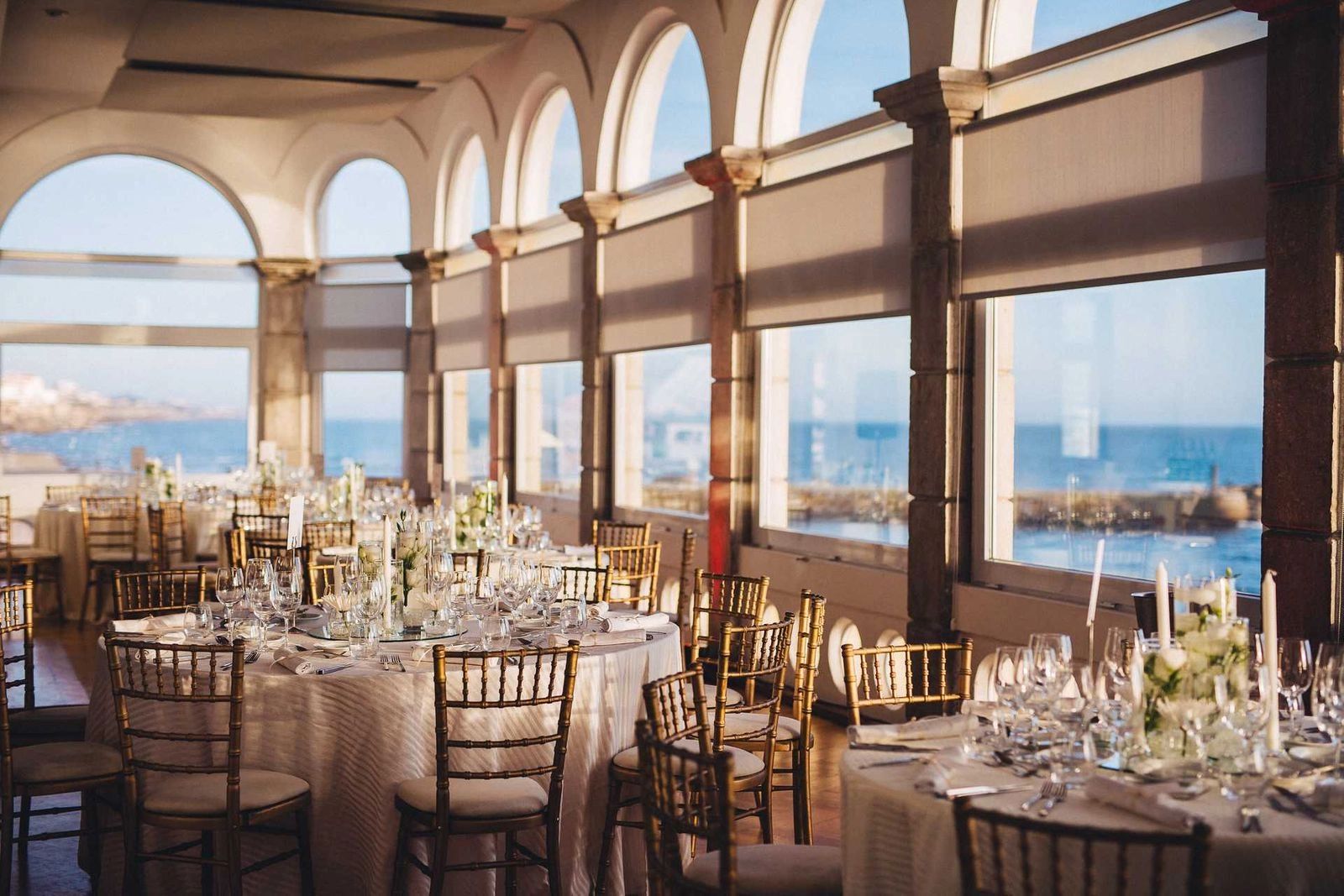 Seaside event venue in Portugal with elegant interiors, high ceilings, and large glass windows lending a view to the sea