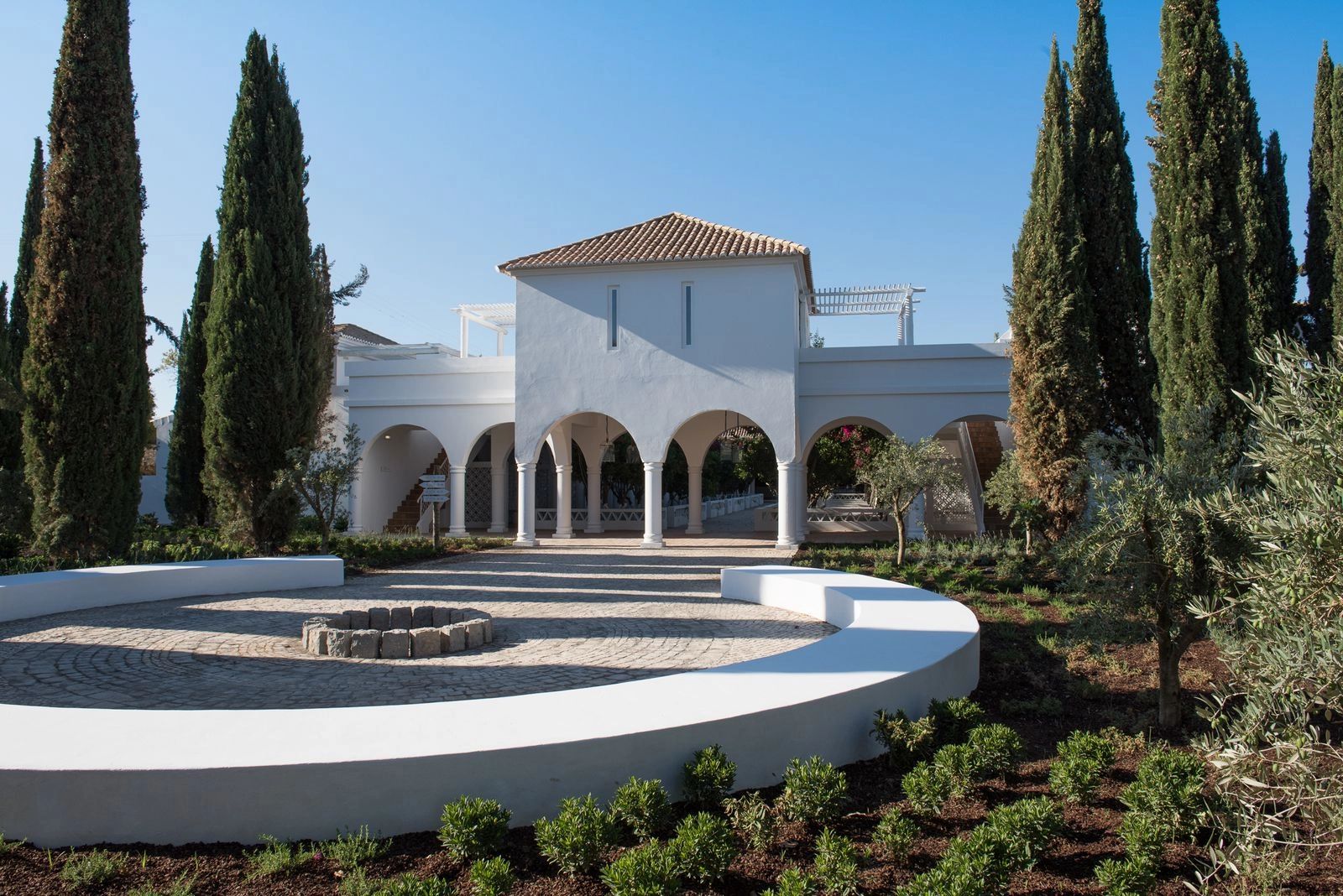 A white farmhouse in Algarve, Portugal, surrounded by tall trees