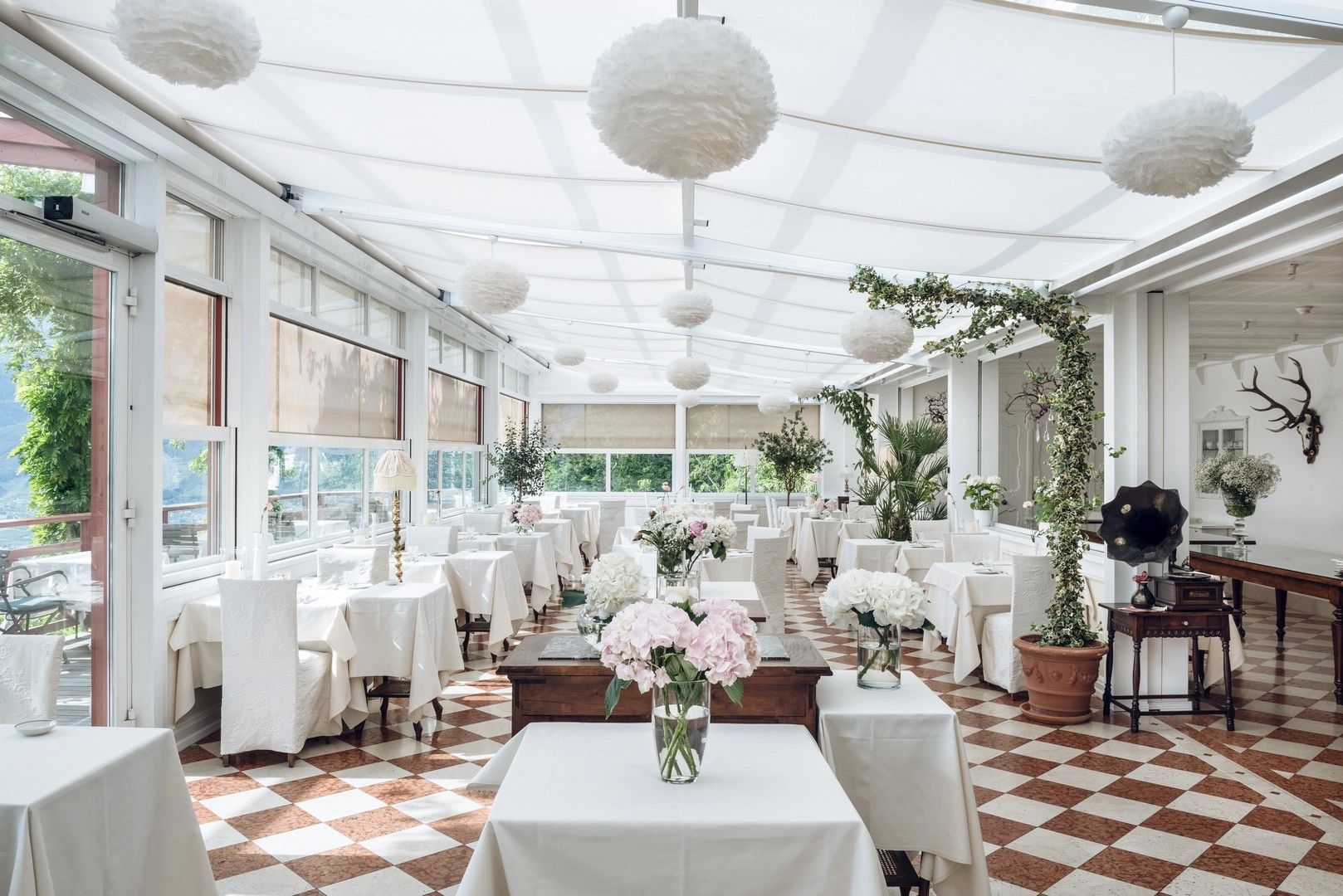 An elegant, chic, and modern boutique hotel in Italy with white interiors, hanging paper lamps, and some greenery inside