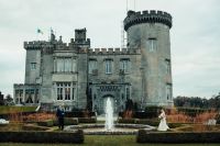 Bride and groom in front of a luxurious castle in county Clare at an elopement in Ireland.