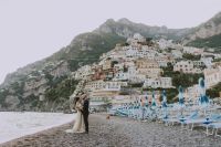 Bride and groom standing on Pistano beach at an elopement in Italy