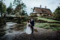 Bride and groom looking at each other in front of a rustic cottage at a wedding in Ireland.