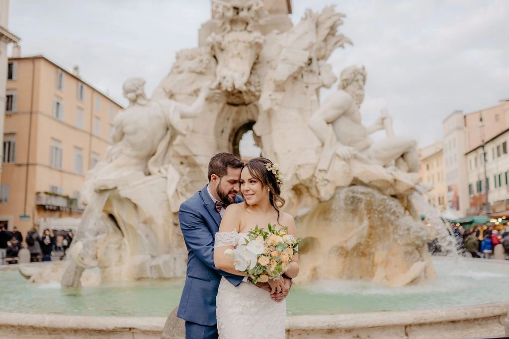 Newlyweds having a romantic photoshoot in front of the Trevi fountain during their elopement in Rome