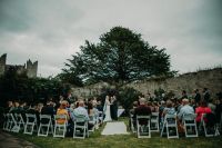 Bride and groom sitting on top of a cliff appreciating the view at a small wedding in Ireland.