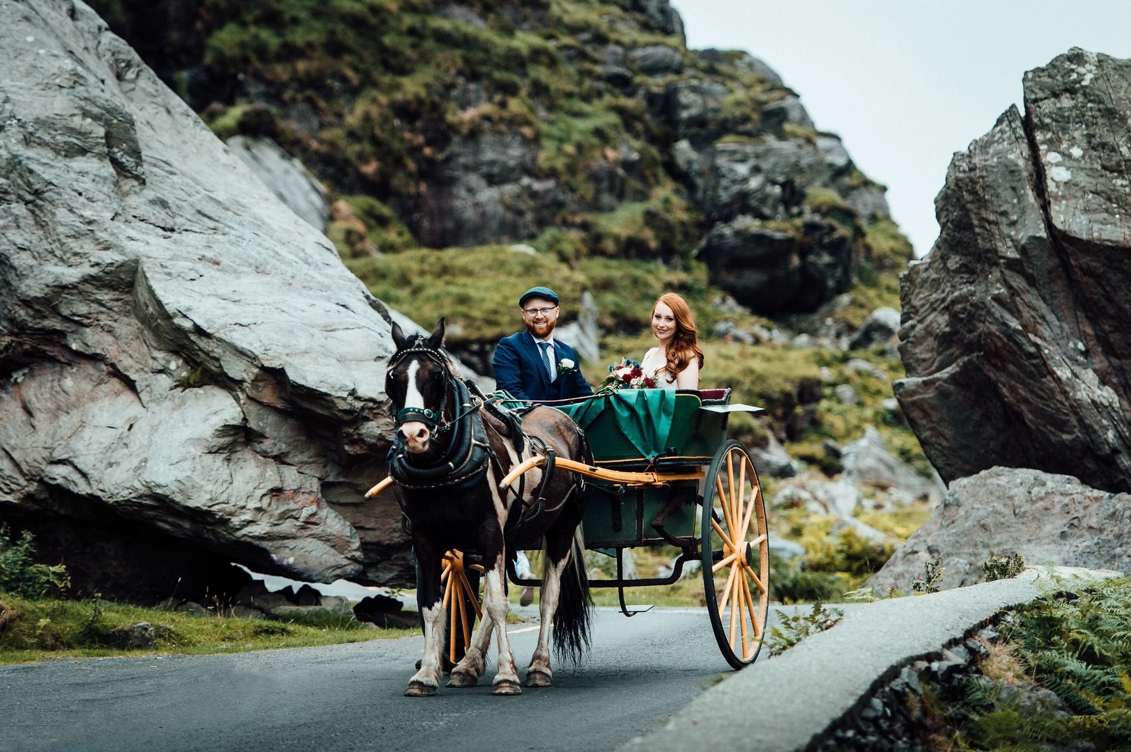 Bride and groom riding a horse and carriage through the Gap of Dunloe in Ireland