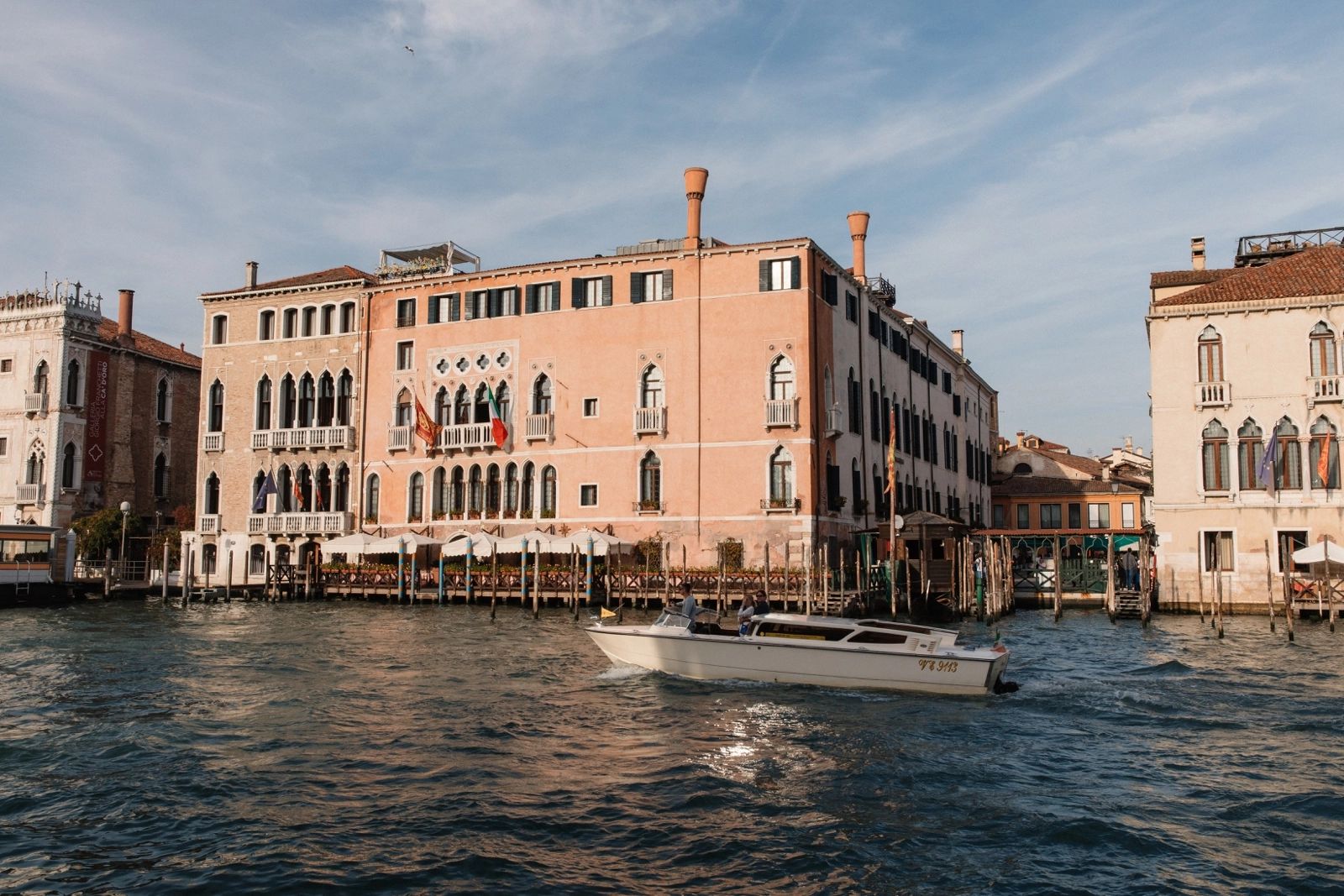 Old hotel and buildings in Venice along the Grand Canal with a sailing boat