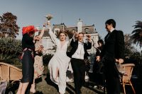 Couple and their guests raising hands in celebration after their wedding in Portugal.