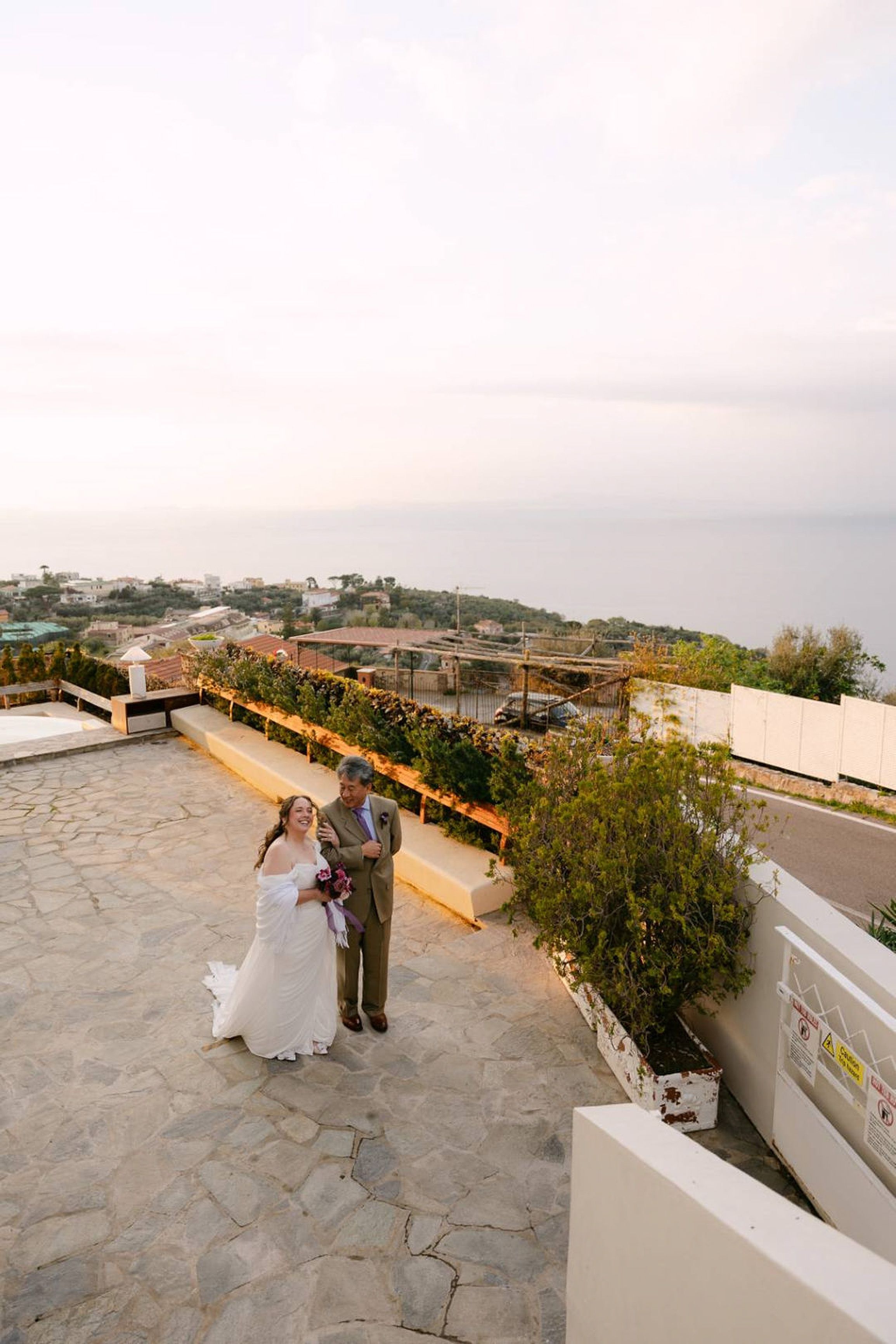 Elevated view of bride and groom on a coastal terrace during an intimate wedding in Italy