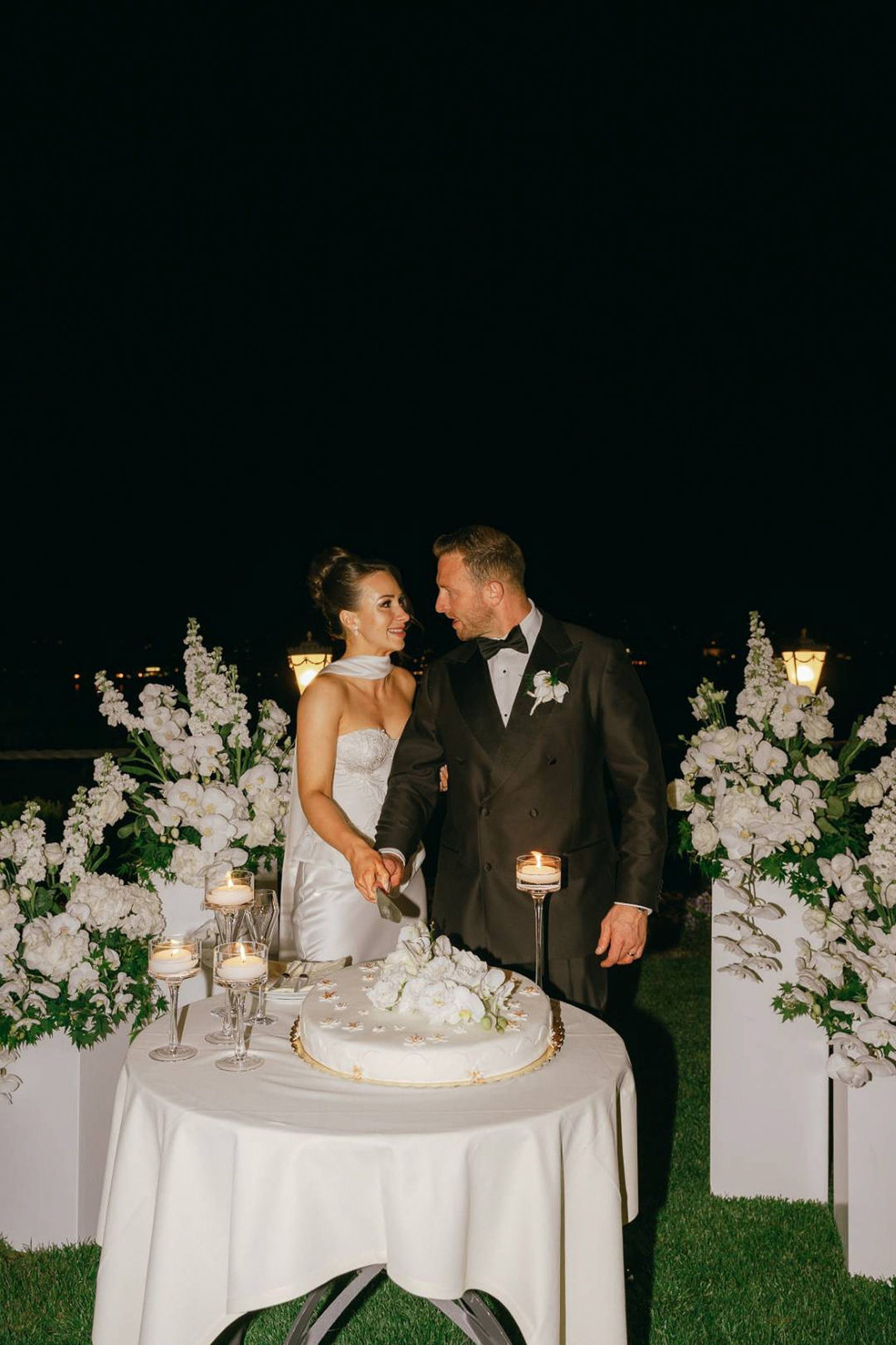 Newlyweds cutting their wedding cake during an intimate wedding in Italy evening reception