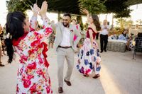 Newlyweds dancing flamenco in semi-formal attire after the ceremony of their small wedding in Spain