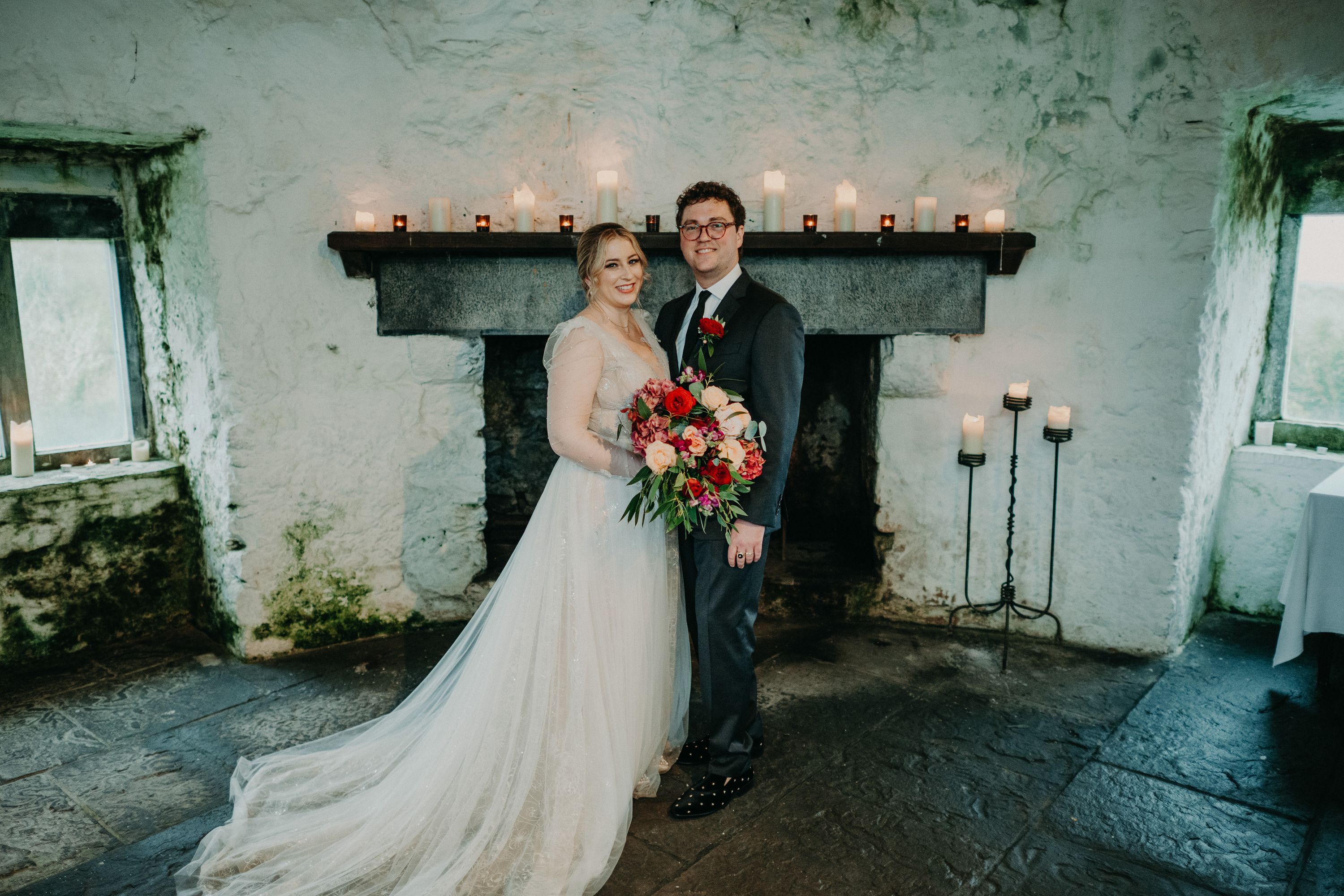 Newlyweds posing with a colorful bouquet after their intimate wedding in Ireland ceremony