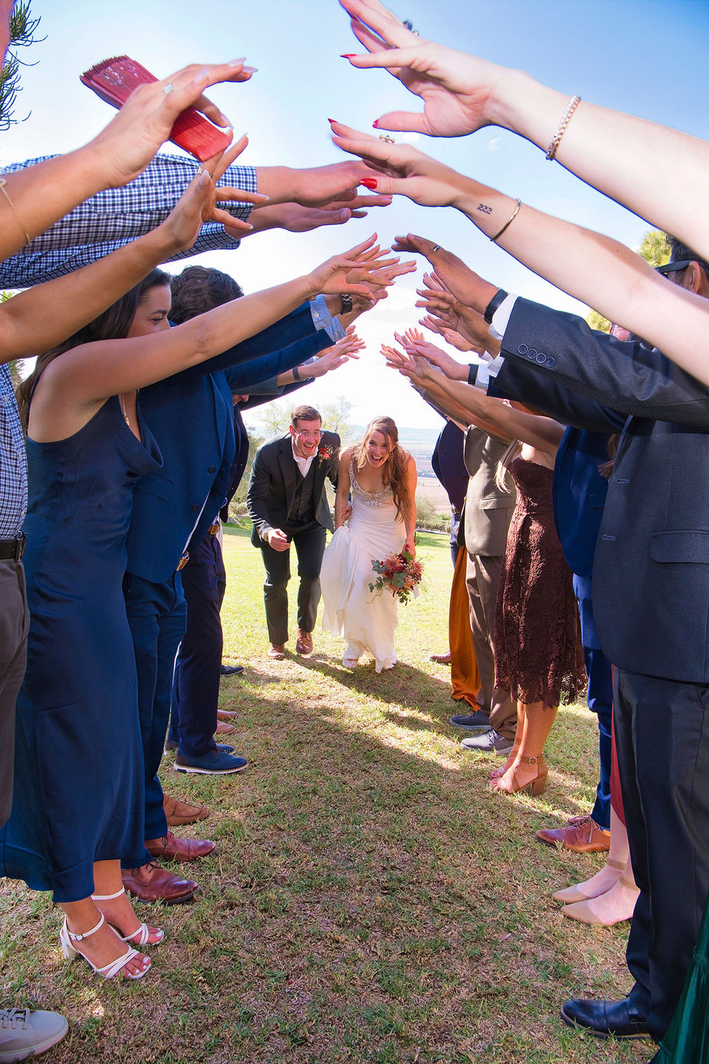Wedding guests forming a celebratory tunnel for newlyweds at a small wedding in Europe