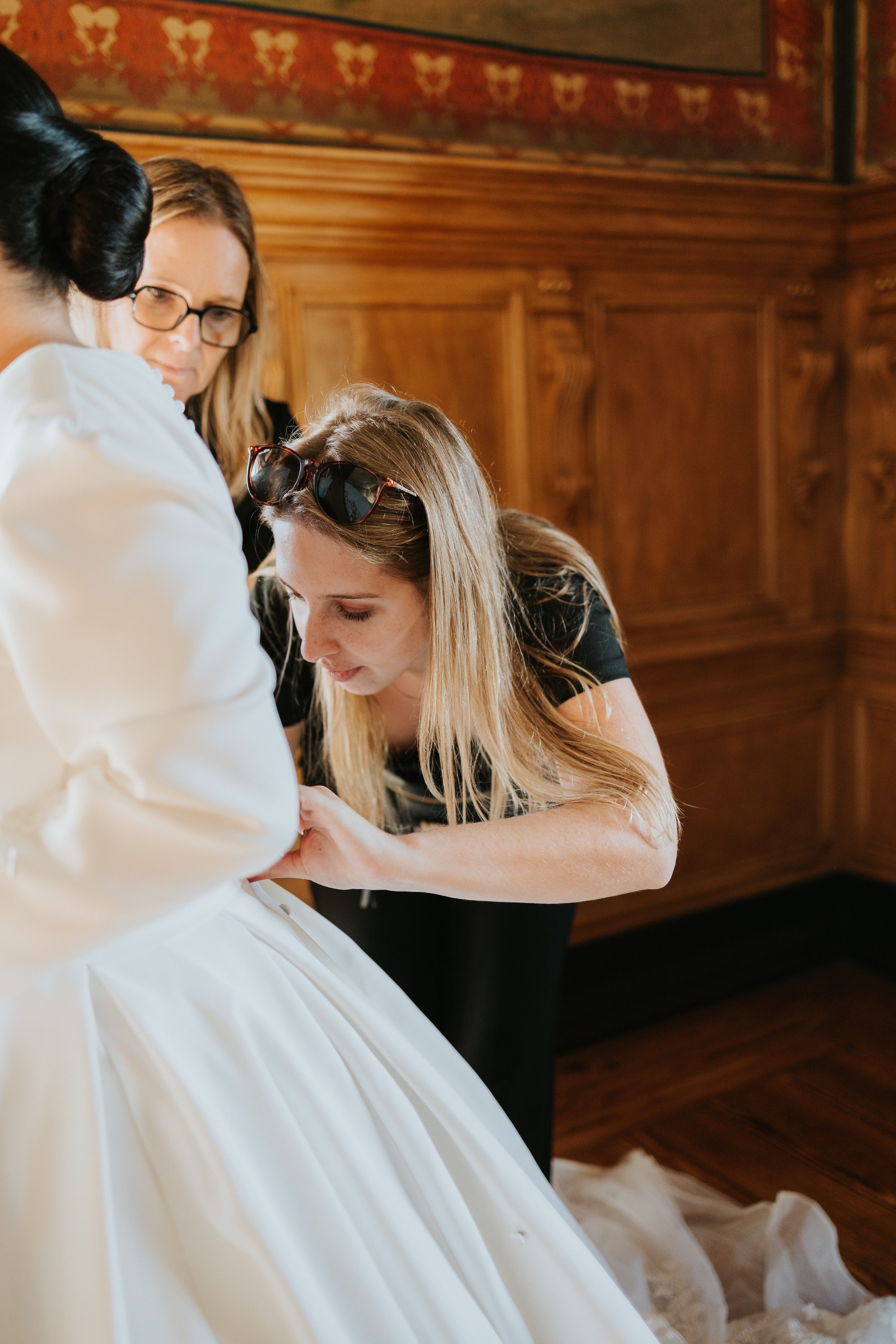 Our wedding planner in Portugal helping the bride fix her dress during their wedding in Portugal