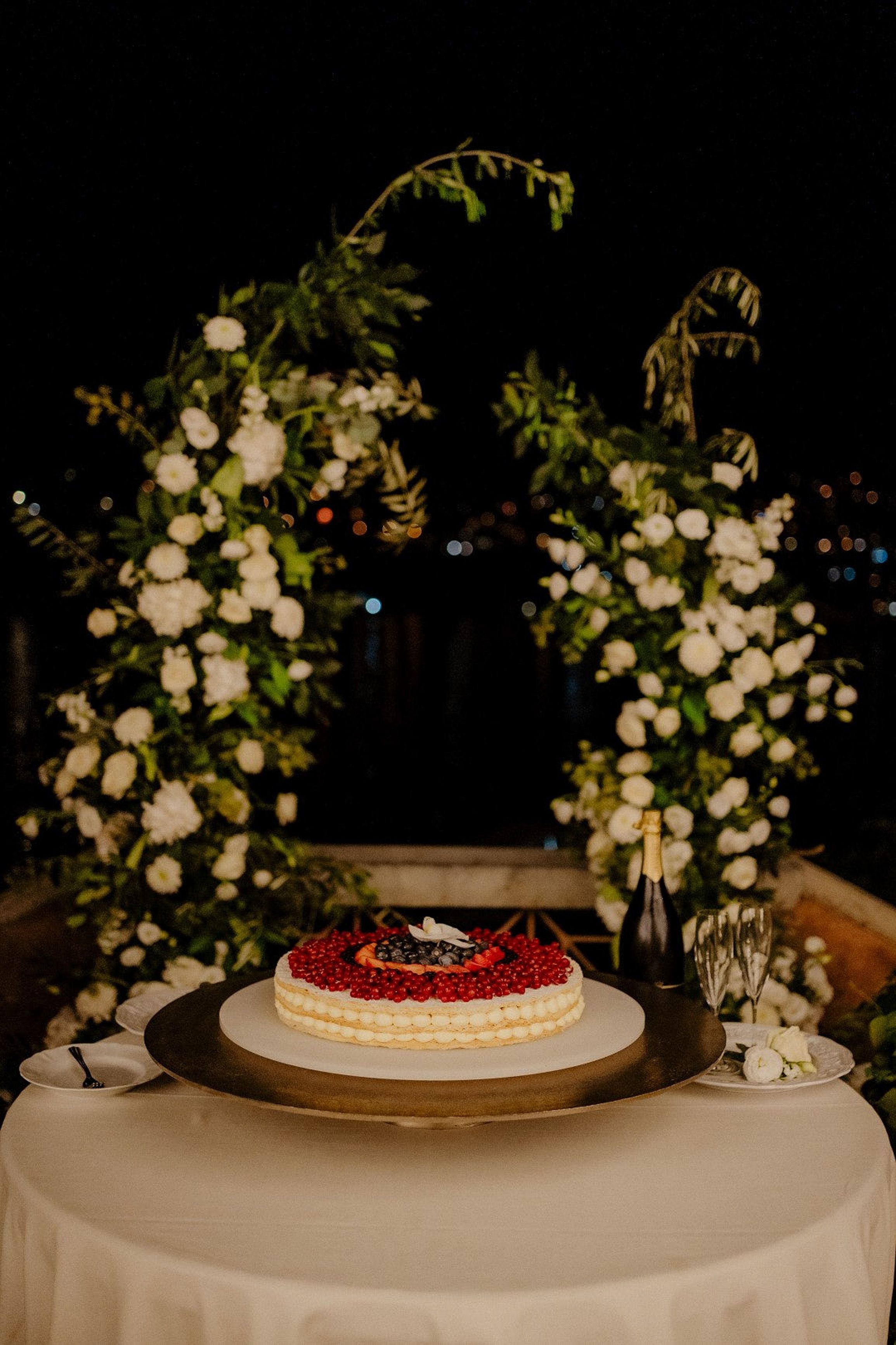 Elegant wedding cake display with champagne and floral décor at a small wedding in Italy reception