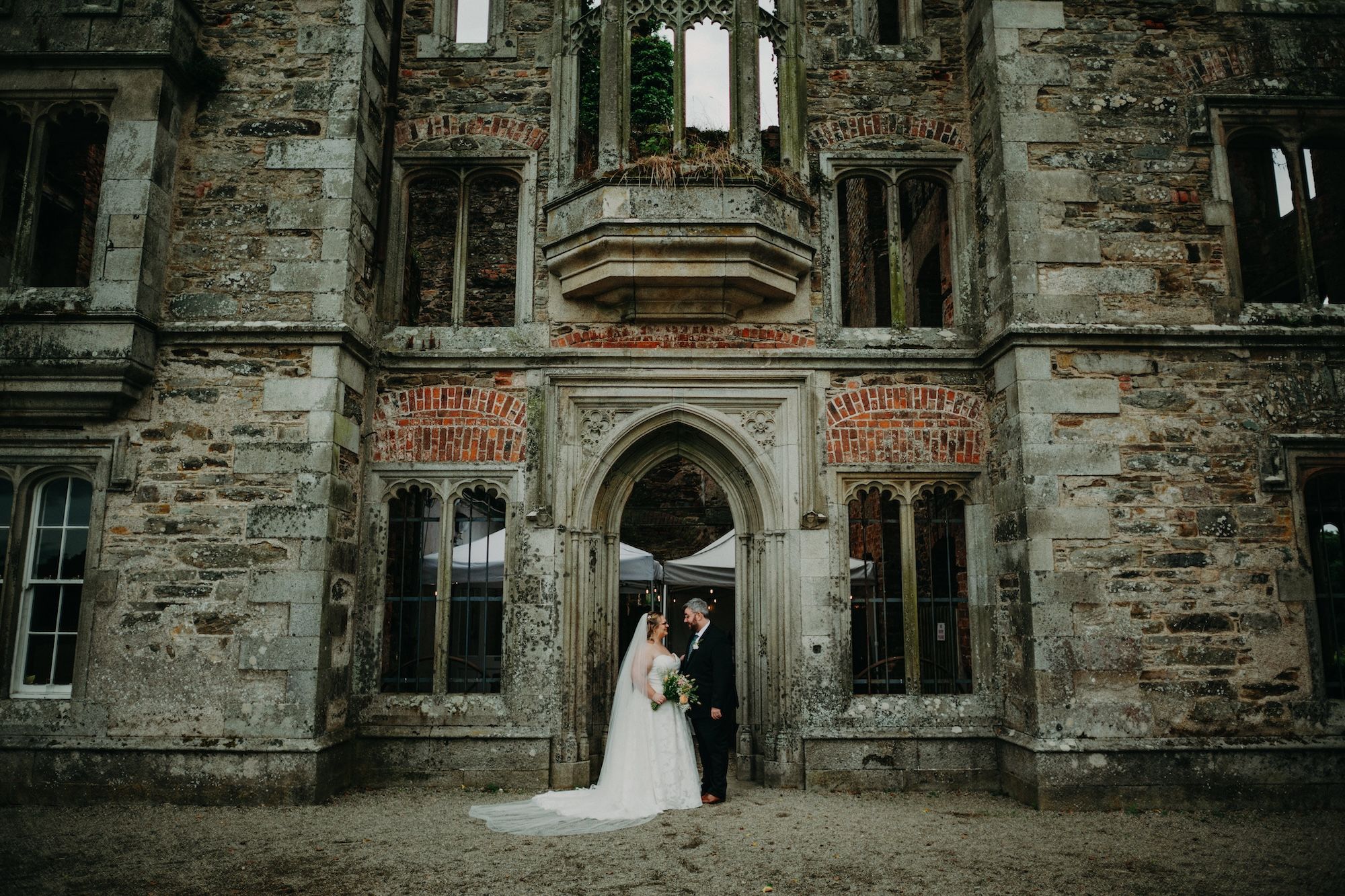 Newlyweds at the entrance of a castle ruin in Ireland