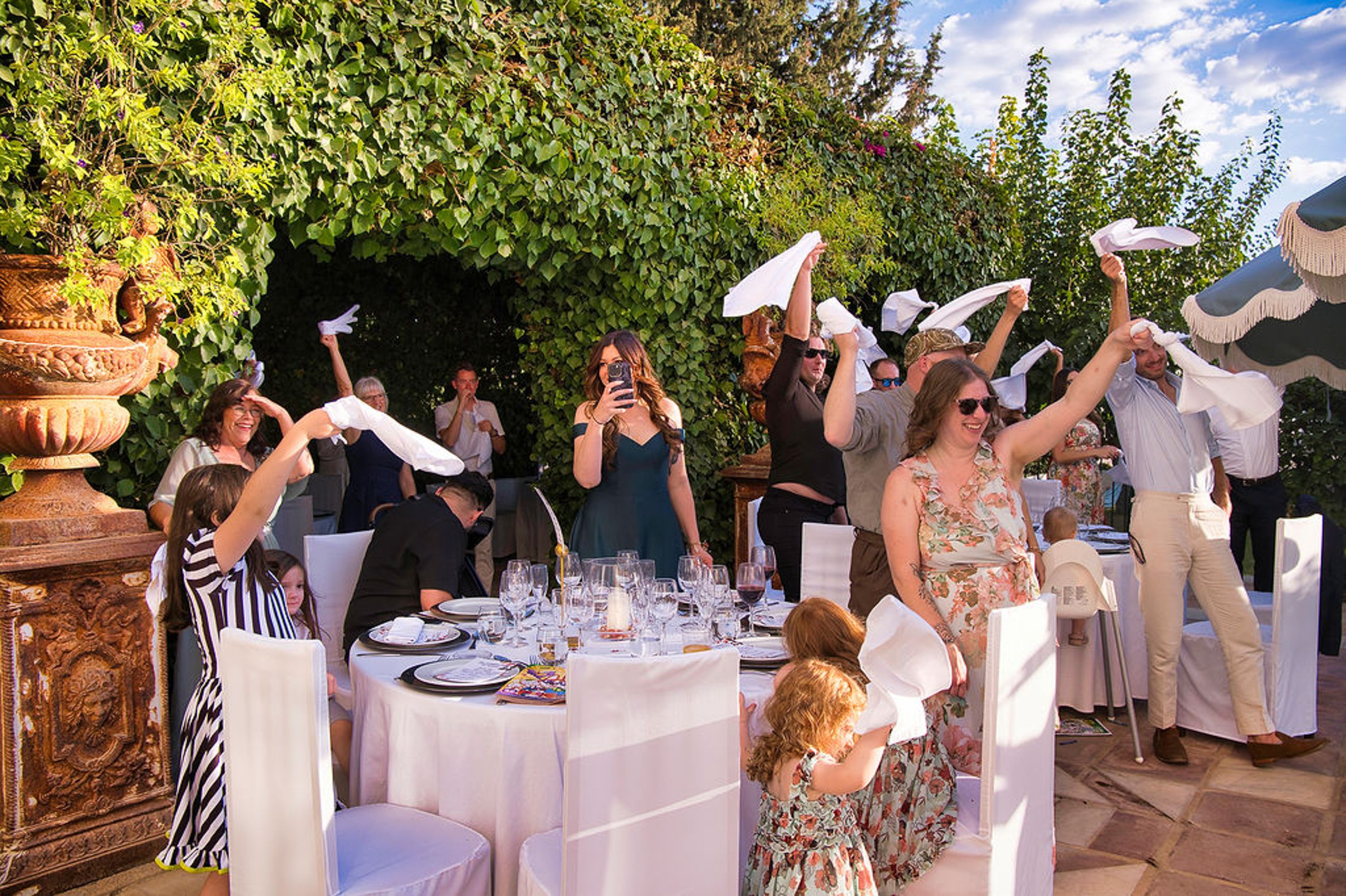 Guests waving white napkins during a lively reception at a small wedding in Europe