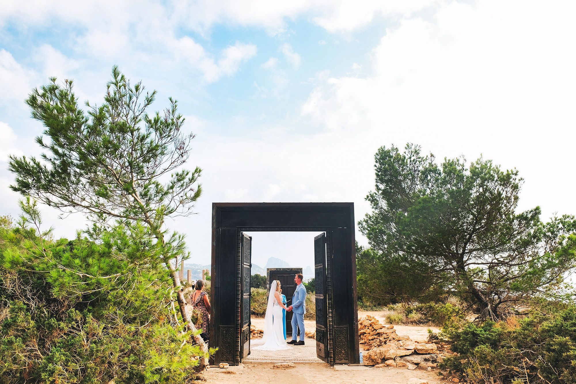 Bride and groom are framed by a door during the ceremony of their autumn destination wedding in Spain