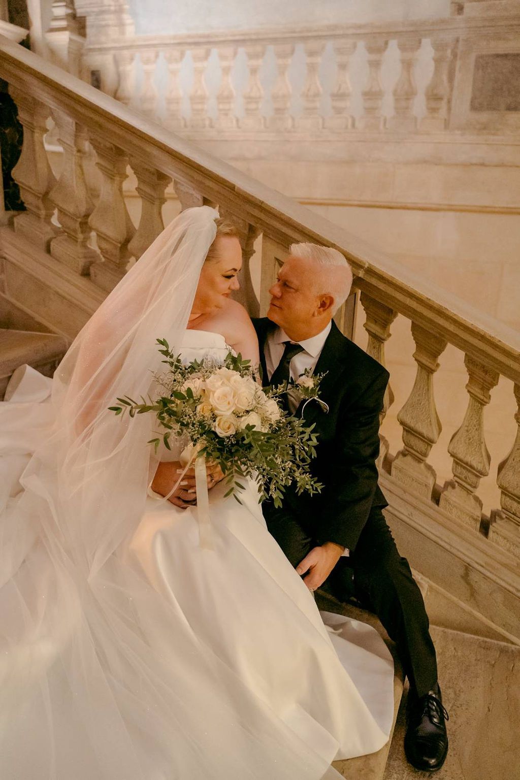Bride holds her white and green minimalist bouquet during her vow renewal in Italy