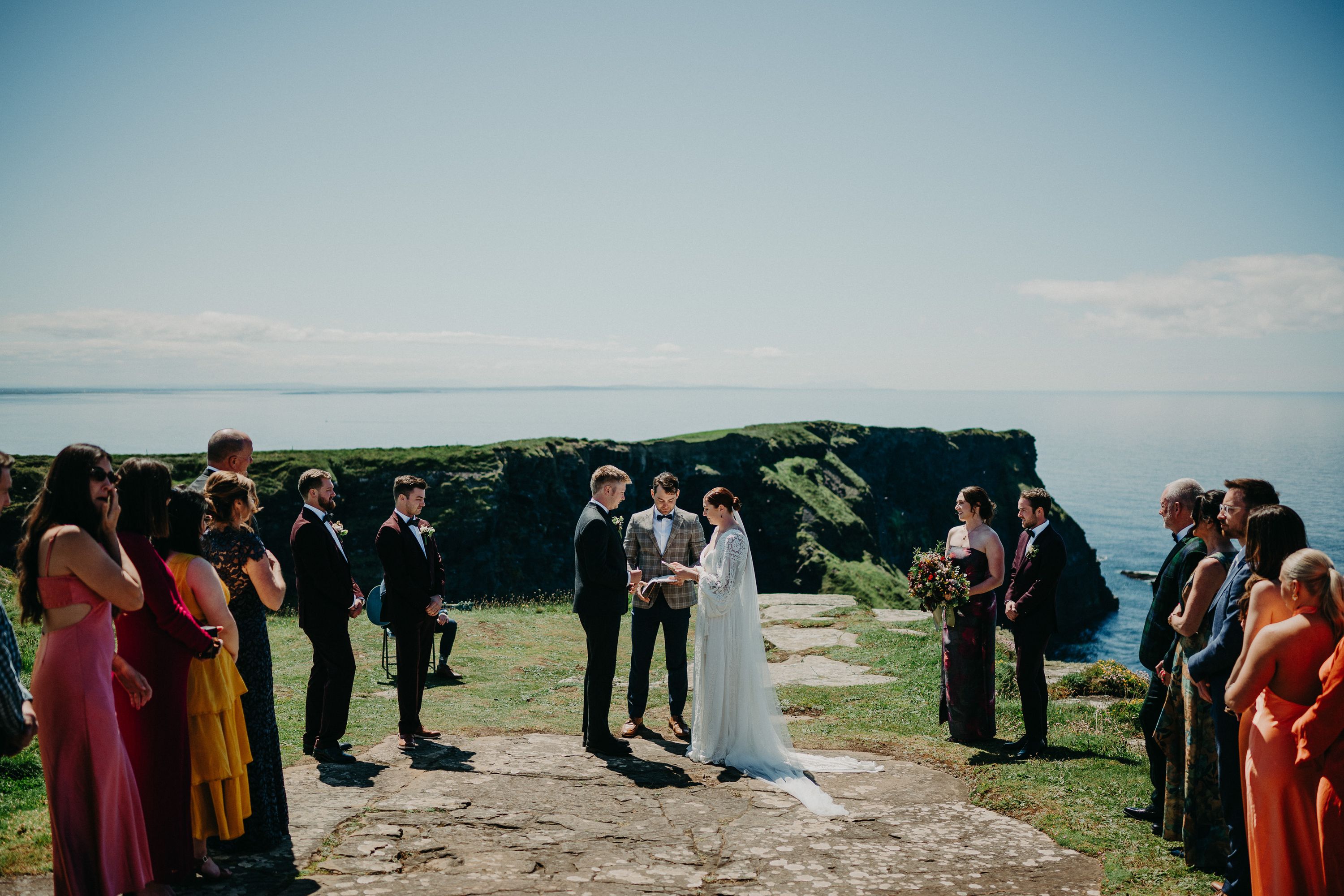 A bride and groom exchanging vows with the entire party looking on during a small wedding in Ireland