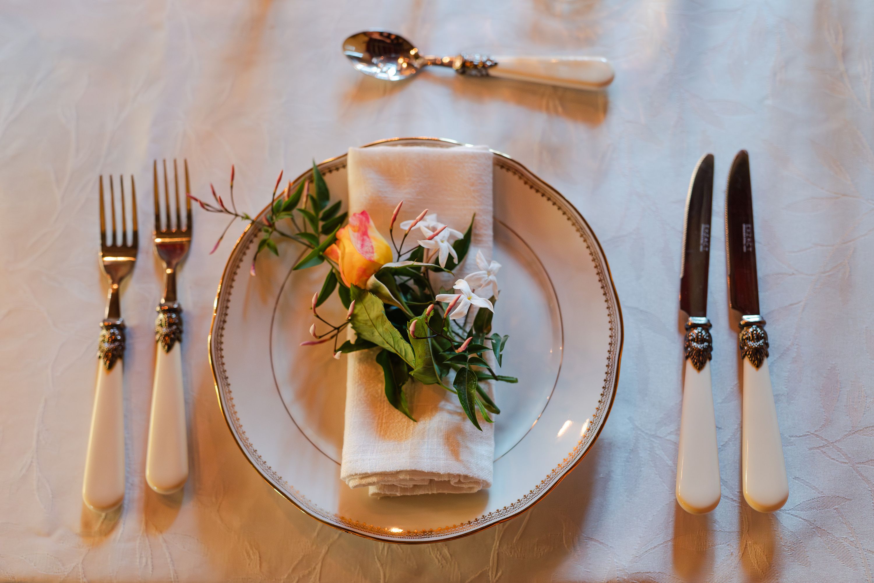 Elegant place setting with floral napkin detail at an intimate wedding in France reception