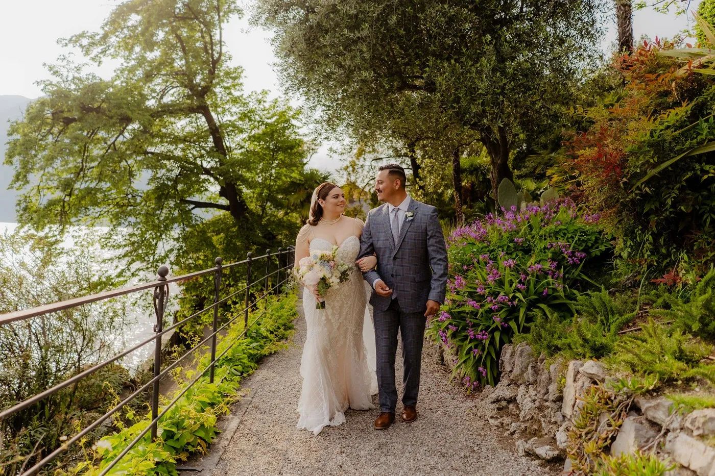 Newlyweds looking at each other as they walk down the outdoor path of a villa where they had an intimate wedding in Italy