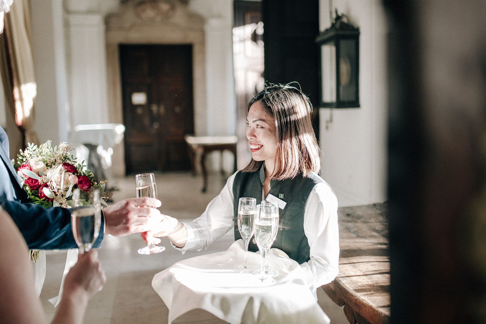 Server pouring sparkling wine after a ceremony in an Austrian palace hall