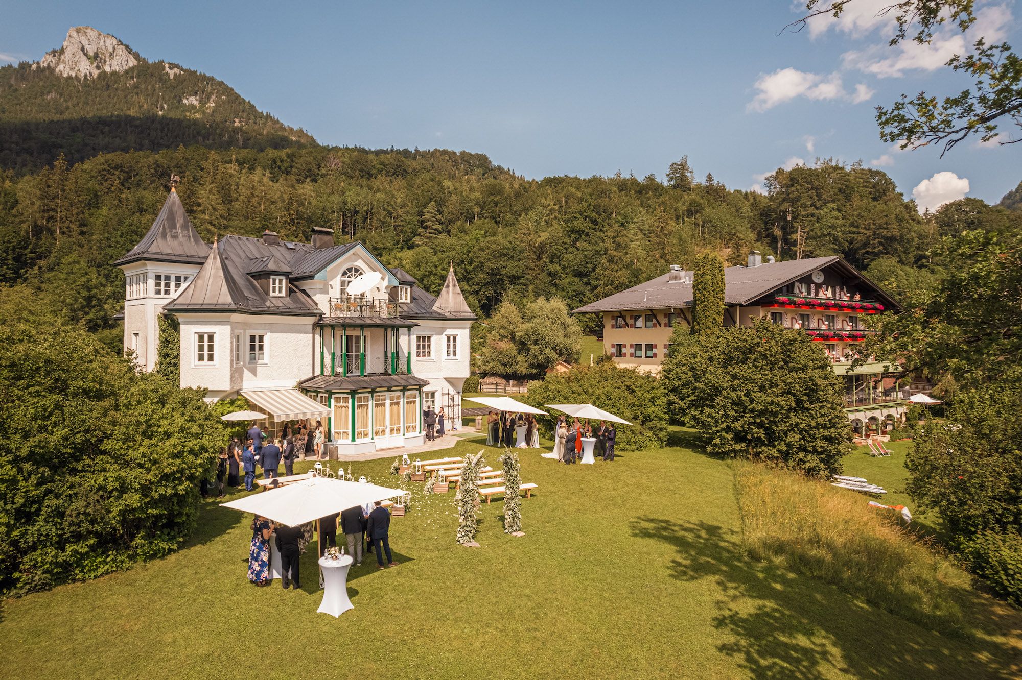 A white castle and a mountain lodge at the foot of the mountains in Austria