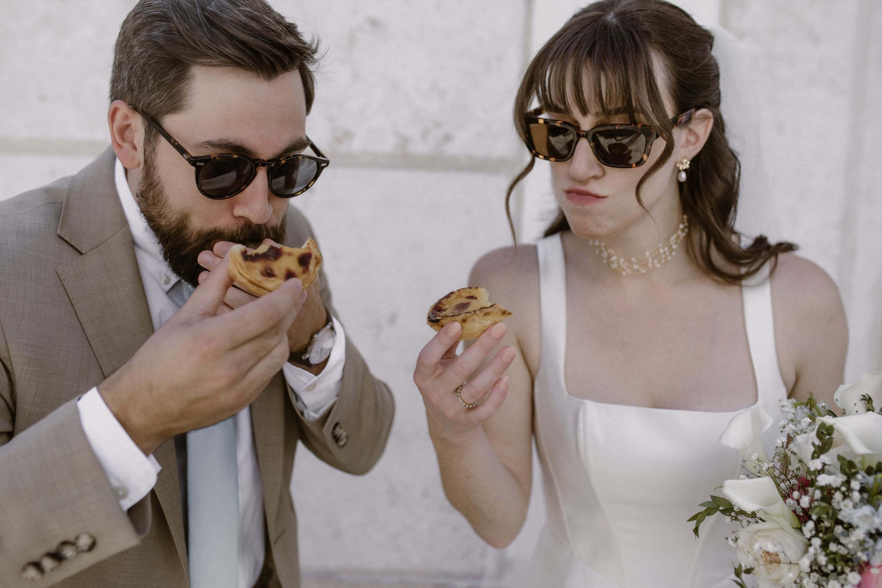Groom enjoying a traditional Portuguese custard tart during a small wedding in Portugal