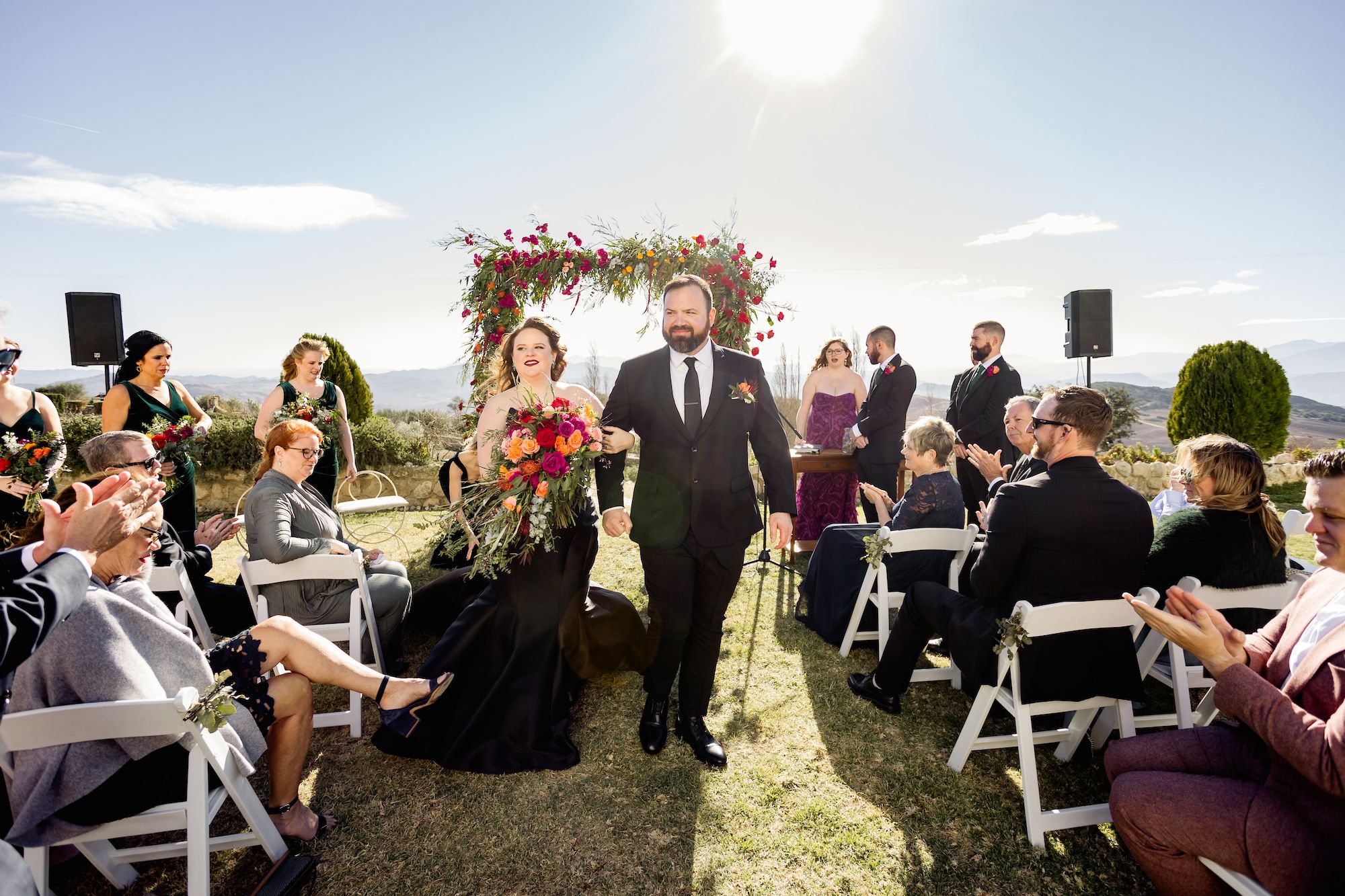 Newlyweds walk down the aisle to end their garden ceremony in Andalusia and start the drinks reception of their Spanish wedding abroad